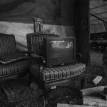 a black and white photo of two chairs and a television