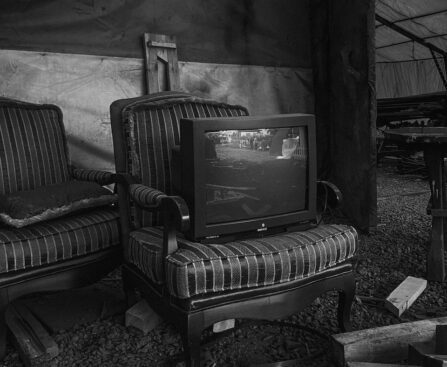 a black and white photo of two chairs and a television