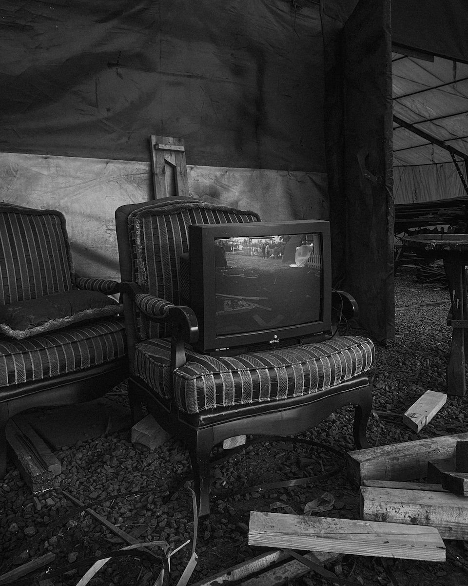 a black and white photo of two chairs and a television