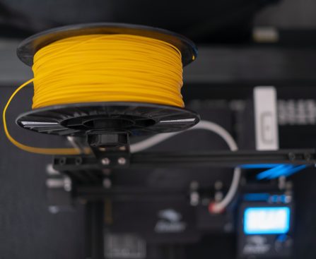 a spool of yellow wire sitting on top of a machine