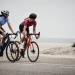 man and woman riding road bikes at the road near shore