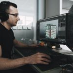 man in black tank top wearing black sunglasses using computer