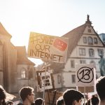 person holding save our internet signage during daytime